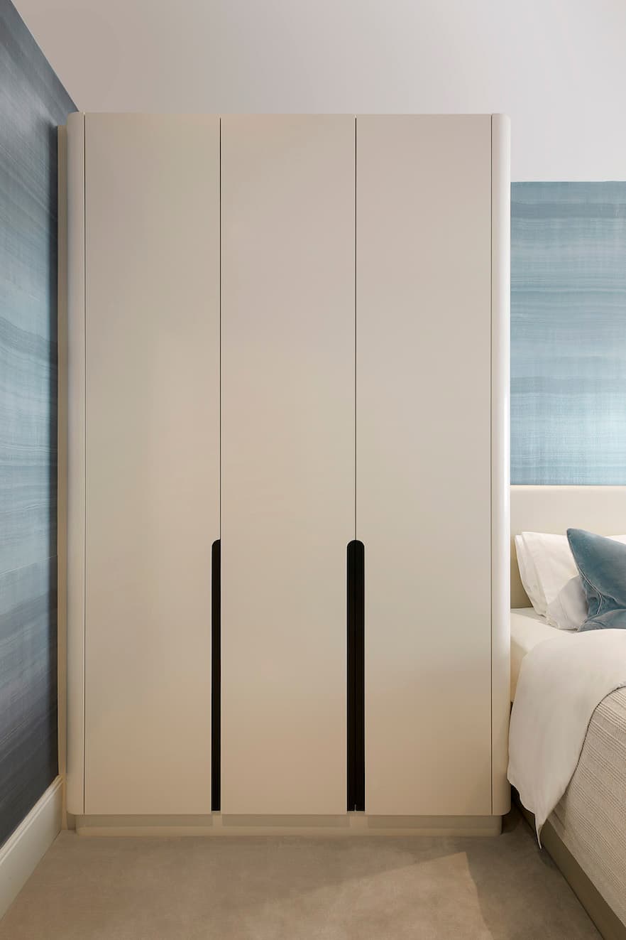 A medium wide shot of a bespoke wardrobe in a bedroom