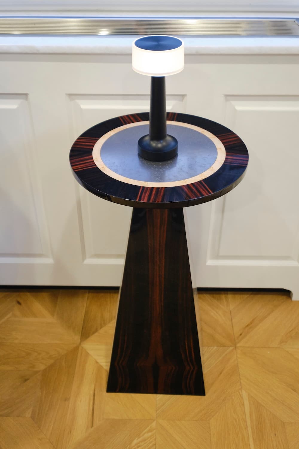 A close up of intricate joinery on a round lounge table with a brass trim